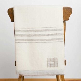 Swans Island's Grace Throw. 100% organic merino wool handwoven in Maine. Shown in white with grey stripes