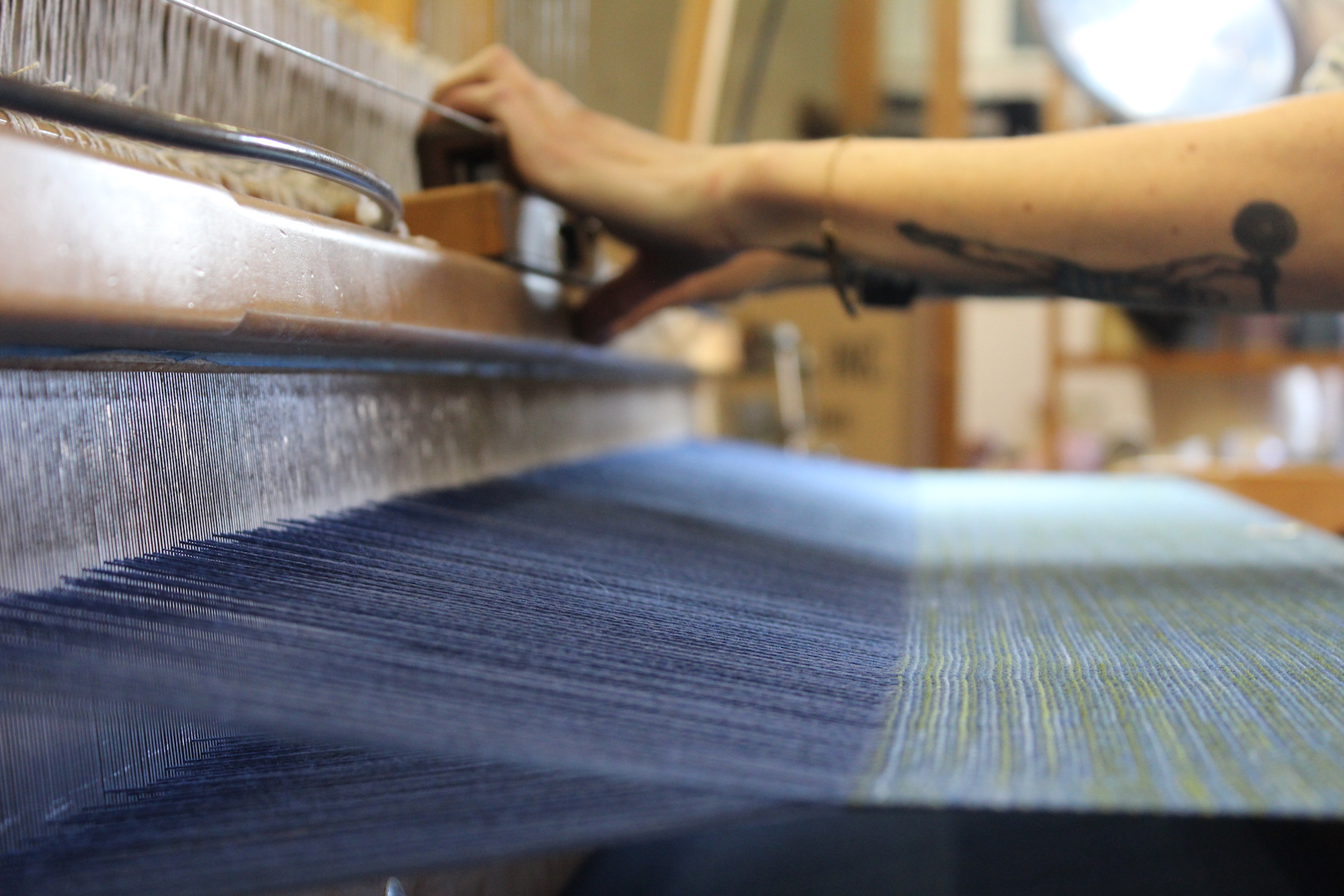 hands operating a weaving loom