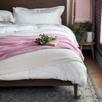 Swans Island Company's Cotton Tulare Blanket. Soft 100% Cotton blanket with yarn-dyed woven stripes. Made in USA with 100% American cotton. Shown here in Rose.