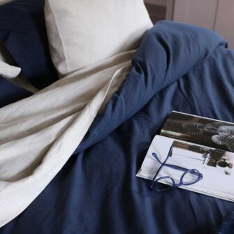 Swans Island Company's Farmhouse Linen Bedding Bundle. Includes 1 Classic Linen Sheet Set in flax + 1 Relaxed Linen Duvet Set in Midnight Blue.