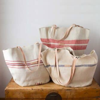 Swans Island Company's Market Basket Tote by Govou. Handcrafted in Spain from vintage linen grain sacks. Each bag is unique. Shown here in natural with red and blue stripes.