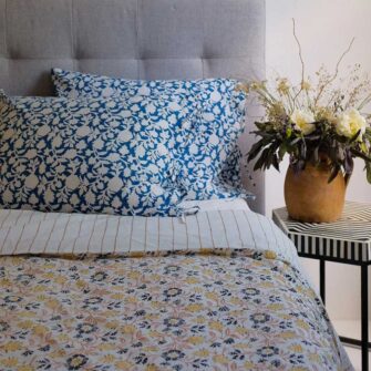 Swans Island Abha Duvet Cover by Soil to Studio. Block printed by hand in India with bright playful patterns. Shown here in natural with gold and blue floral.