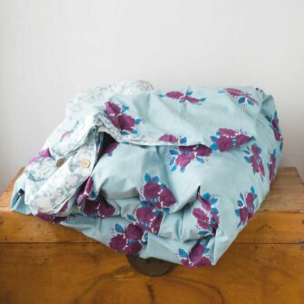 Swans Island Company's Sara Duvet Cover by Soil to Studio. Block printed by hand in India with bright playful patterns. Shown here in Denim with roses.