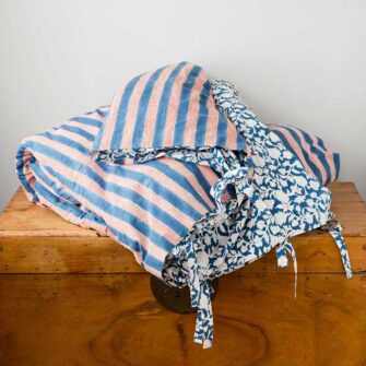 Swans Island Company's Indu Duvet Cover by Soil to Studio. Block printed by hand in India with bright playful patterns. Shown here in Indigo with Red Stripe. With tie closure detail.