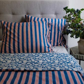 Swans Island Company's Indu pattern by Soil to Studio. Block printed by hand in India with bright playful patterns. Shown here in Indigo with Red Stripe.