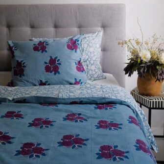 Swans Island Company's Sara Duvet Cover by Soil to Studio. Block printed by hand in India with bright playful patterns. Shown here in Denim with roses.