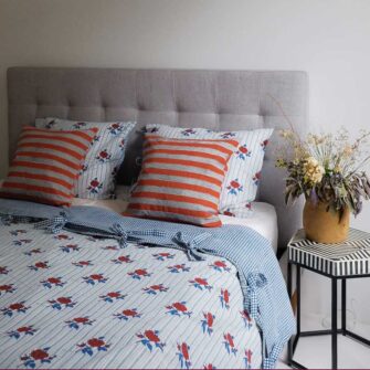 Swans Island Company's Supriya pattern by Soil to Studio. Block printed by hand in India with bright playful patterns. Shown here in Aqua with red roses. Swatch