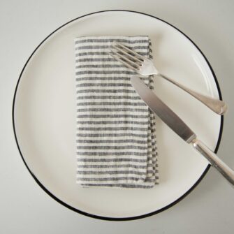 Swans Island Company's linen napkins by Linen Tales, made with 100% European Linen Oeko-Tex® and EUROPEN FLAX® certified. Made with stonewashed soft linen with mitered corners for a crisp edge. Shown here in Thin Black Stripe.