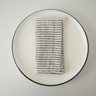 Swans Island Company's linen napkins by Linen Tales, made with 100% European Linen Oeko-Tex® and EUROPEN FLAX® certified. Made with stonewashed soft linen with mitered corners for a crisp edge. Shown here in Thin Black Stripe.