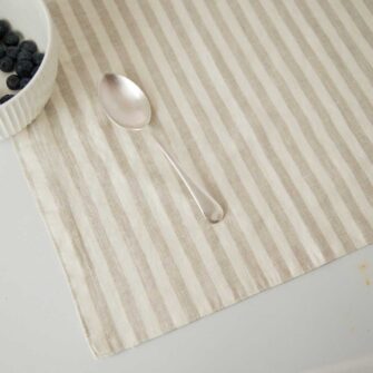 Swans Island Company's linen placemats by Linen Tales, made with 100% European Linen Oeko-Tex® and EUROPEN FLAX® certified. Made with stonewashed soft linen with mitered corners for a crisp edge. Shown here in Natural White Stripe.