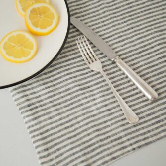 Swans Island Company's linen placemats by Linen Tales, made with 100% European Linen Oeko-Tex® and EUROPEN FLAX® certified. Made with stonewashed soft linen with mitered corners for a crisp edge. Shown here in Thin Black Stripe.