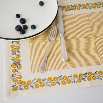 Swans Island Company's Shika Placemat by Soil to Studio. Block printed by hand in India with bright playful patterns. Shown here in Natural with daffodil yellow.