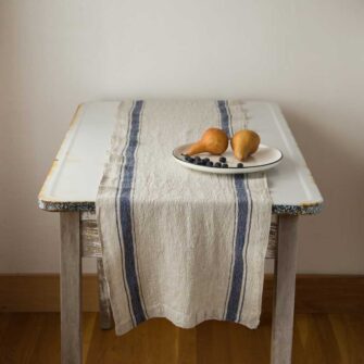 Swans Island Company's linen table runner by Linen Tales, made with 100% European Linen Oeko-Tex® and EUROPEN FLAX® certified. Made with stonewashed soft linen with mitered corners for a crisp edge. Shown here in Vintage Blue stripe on Flax.