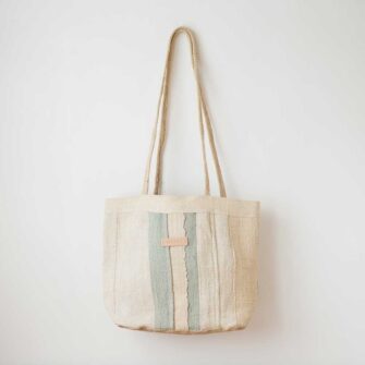 Swans Island Company's Govou Quilted Tote Bag is madein Spain. Antique grain sacks are reimagined into unique tote bags. Shown here in nature with Light Blue.